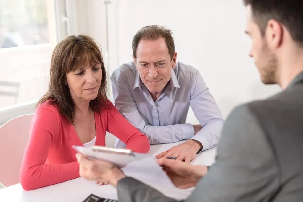 Two people looking over documents with their lawyer.