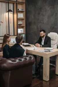 An attorney sitting at his desk speaking with a couple.