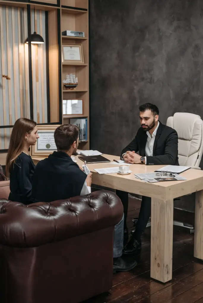 An attorney sitting at his desk speaking with a couple.