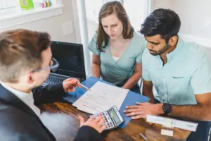 An attorney speaking with a couple and going over paperwork.