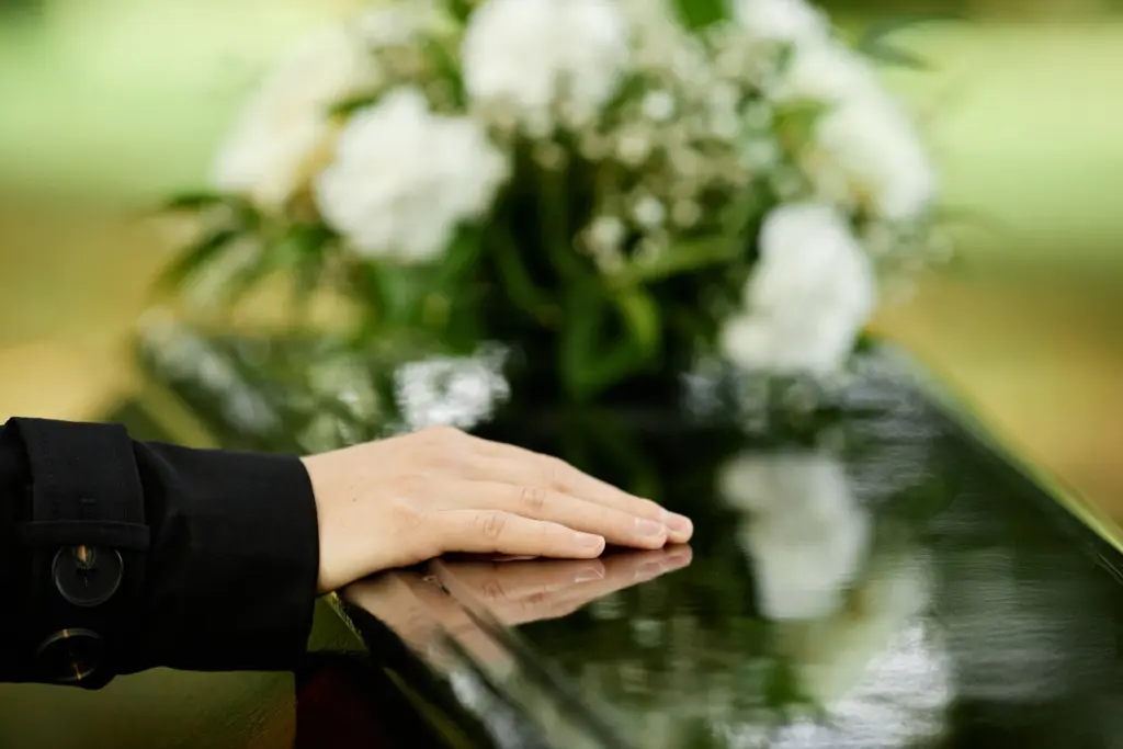 A hand resting on a casket.