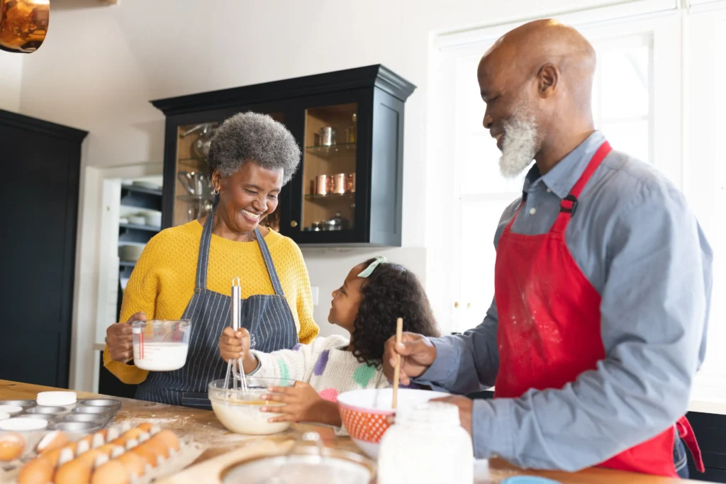 Grandparents baking something with their granddaughter.