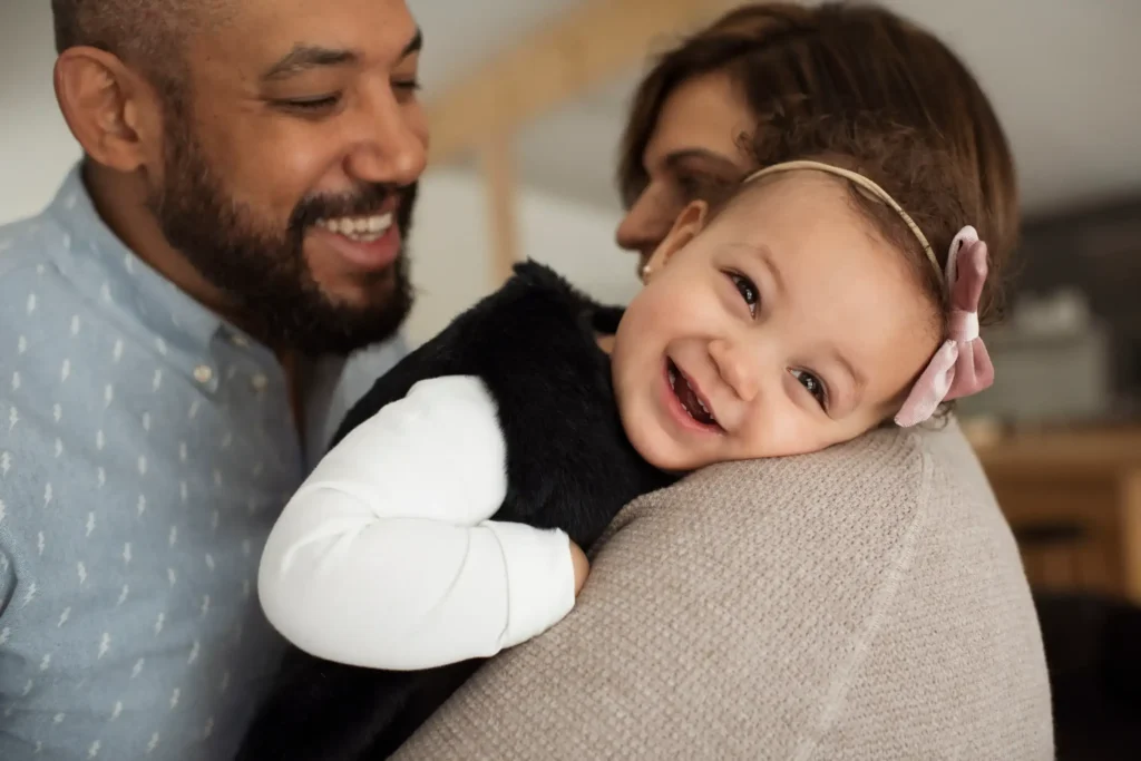 A couple laughing with a baby.