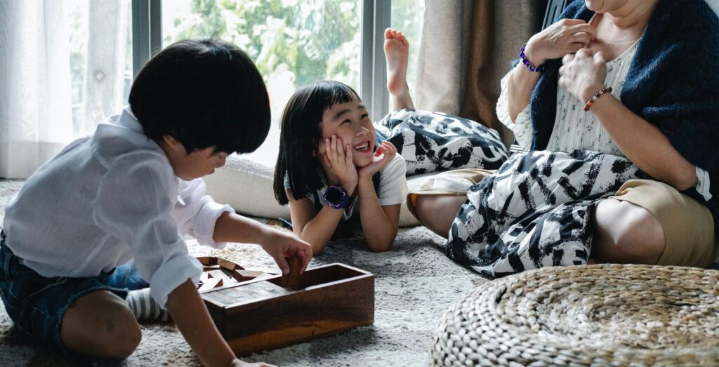 Two children playing games with an adult.