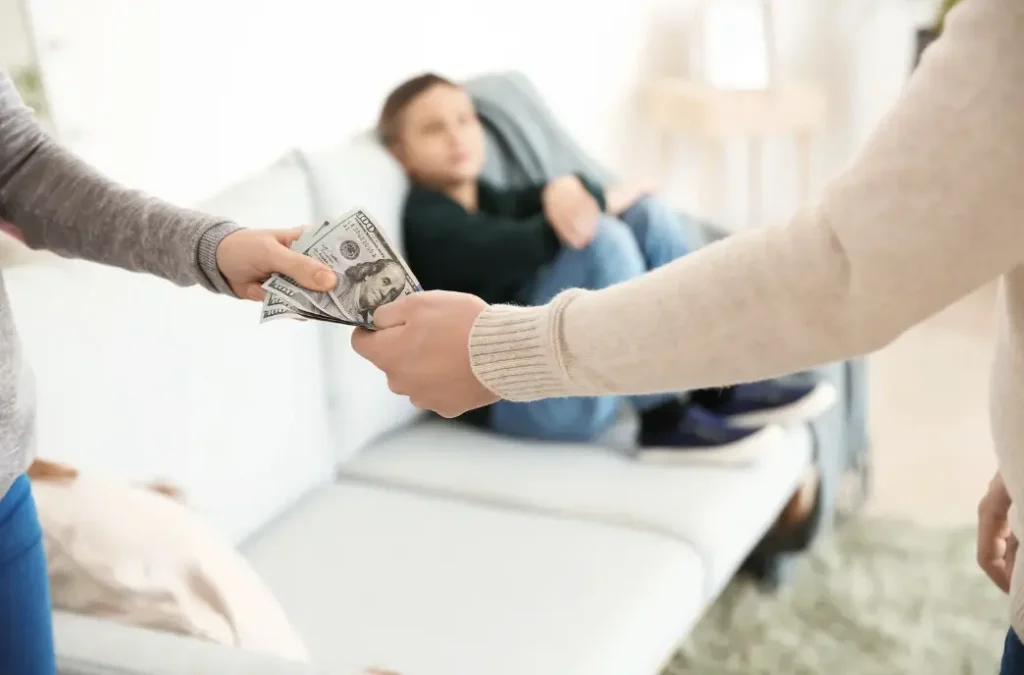 Man handing cash to woman as spousal support payment.